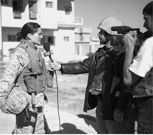 Arab news reporters conduct an on site interview with MAJ M.N. Hawkins, 4th Civil Affairs Group, in front of the Dr. Talib Al-Janabi Hospital.
